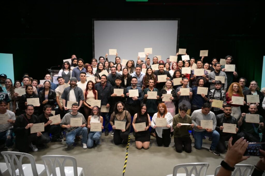 Estudiantes de Medellín celebrando con sus certificados de formación en habilidades digitales y audiovisuales otorgados por la Alcaldía.