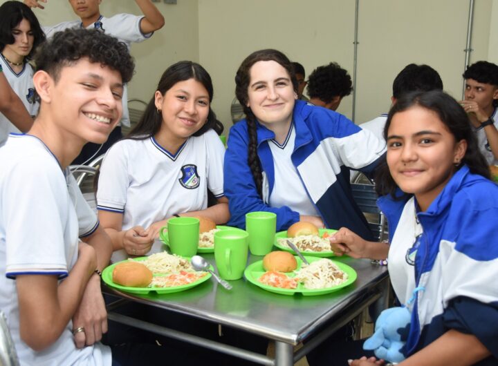 estudiantes de bachillerato en Medellín sonríen mientras disfrutan de su almuerzo