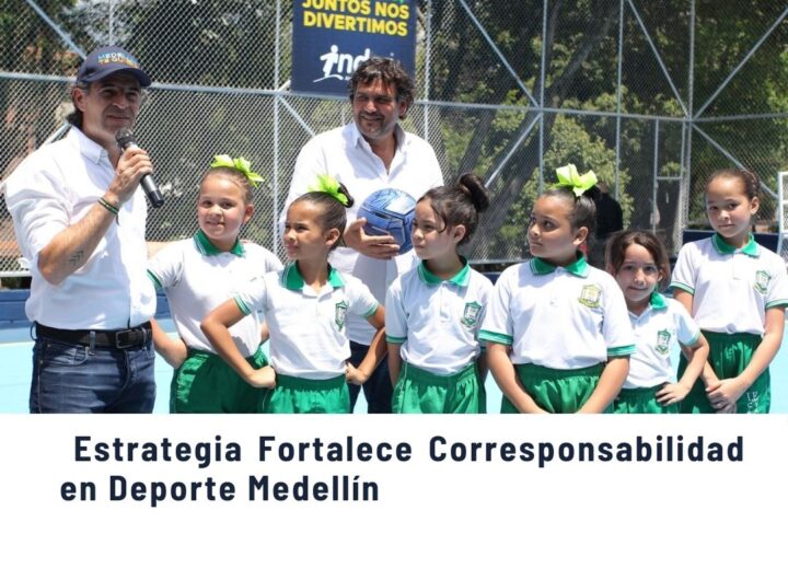 Niñas en uniforme escolar junto a autoridades en una cancha deportiva de Medellín, promoviendo la estrategia que fortalece la corresponsabilidad en el deporte.