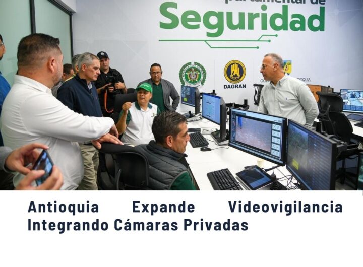 Grupo de personas en el Nodo Departamental de Seguridad de Antioquia discutiendo la expansión de videovigilancia mediante la integración de cámaras privadas, con logos de DAGRAN y Gobernación de Antioquia.