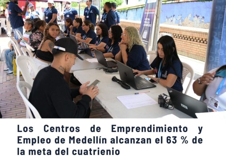Grupo de personas en un evento de los Centros de Emprendimiento y Empleo de Medellín, trabajando con laptops bajo una carpa, alcanzando el 63% de la meta del cuatrienio.
