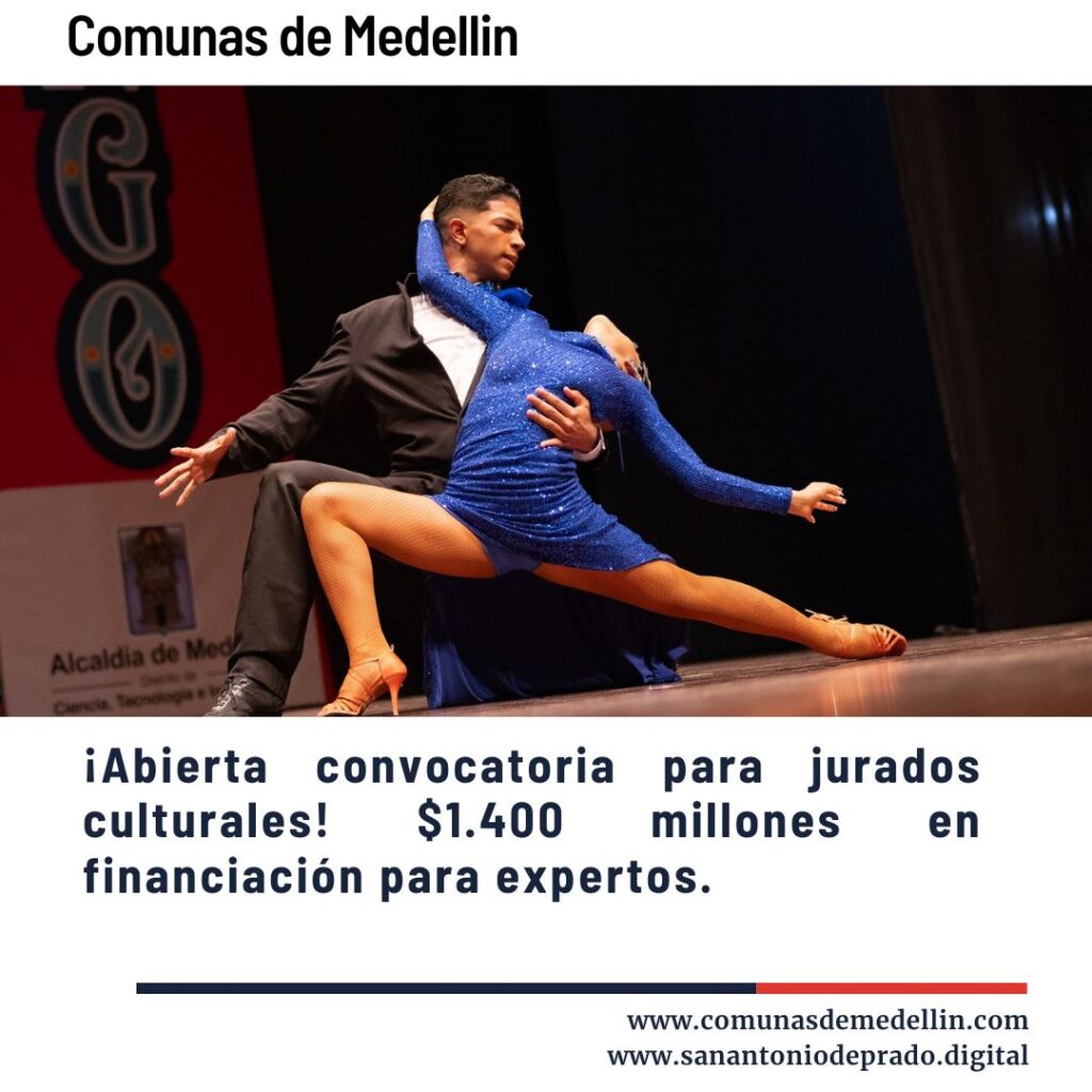 Pareja de bailarines profesionales en intensa pose de baile latino en escenario, con vestuario brillante azul y negro, durante evento cultural en Medellín.