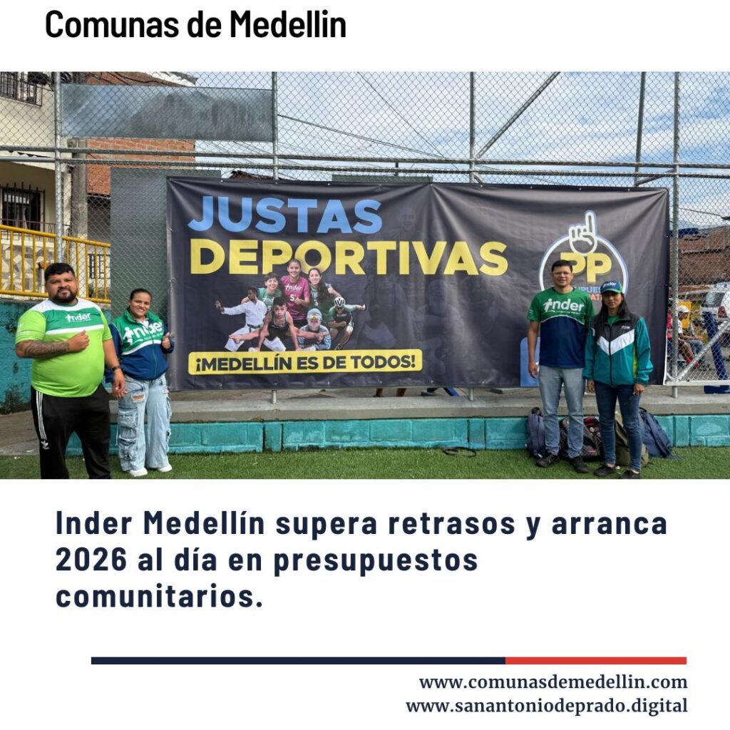 Grupo de personas posando frente a un banner de "Justas Deportivas" del Inder Medellín en una cancha comunitaria, destacando que el Inder supera retrasos y arranca 2026 al día en presupuestos comunitarios.