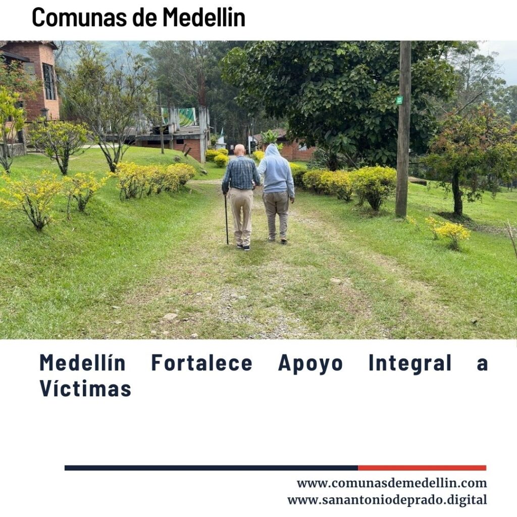 Dos personas mayores caminando por un sendero verde rodeado de arbustos amarillos y vegetación, en un paisaje rural de Medellín, ilustrando el fortalecimiento del apoyo integral a víctimas.