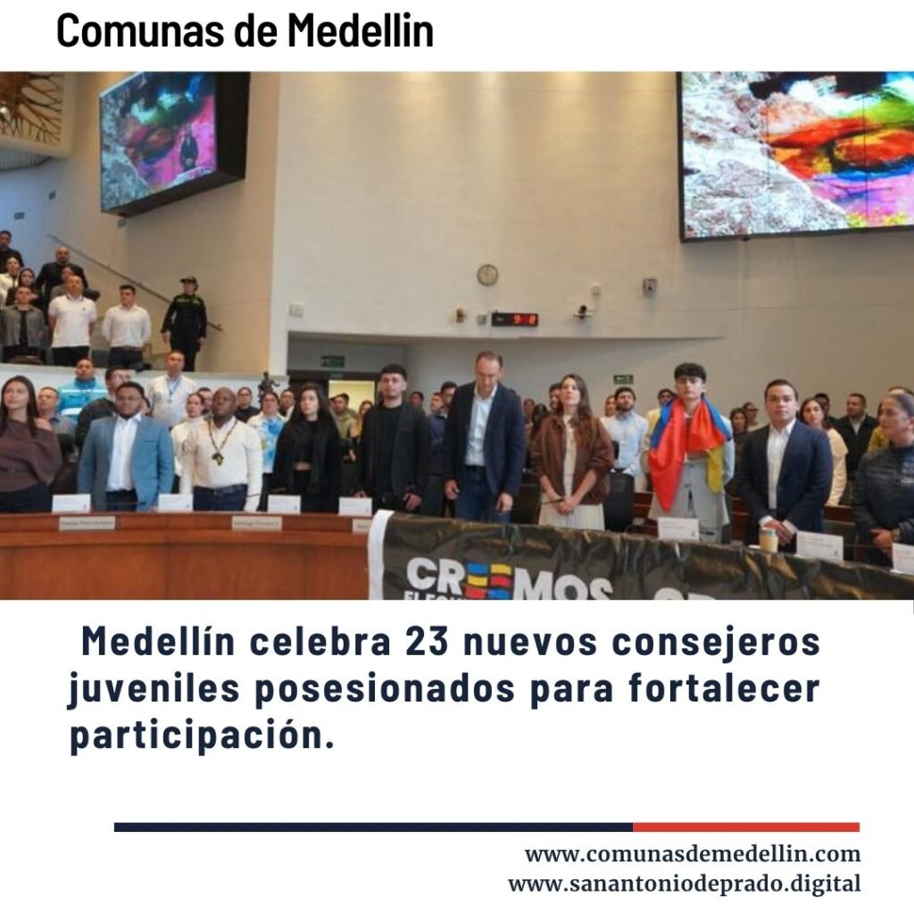 Ceremonia de posesión de 23 nuevos consejeros juveniles en Medellín, grupo en tarima con banderas y público en auditorio, fortaleciendo participación juvenil - Comunas de Medellín.