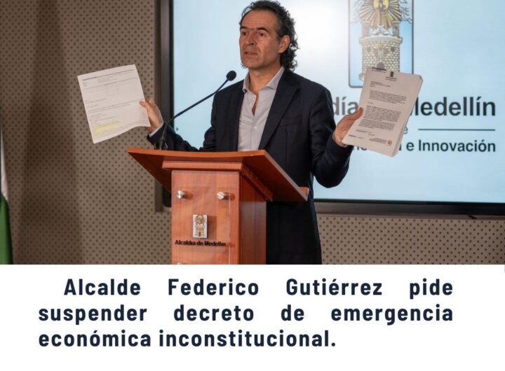 Alcalde o funcionario en podio solicitando a la Corte Constitucional frenar efectos de reforma tributaria nacional, con banderas de Colombia y escudo de Medellín - Comunas de Medellín.